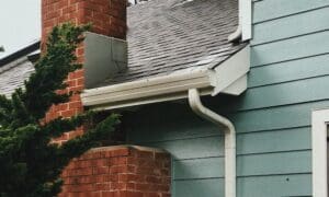 green-blue siding with white gutters