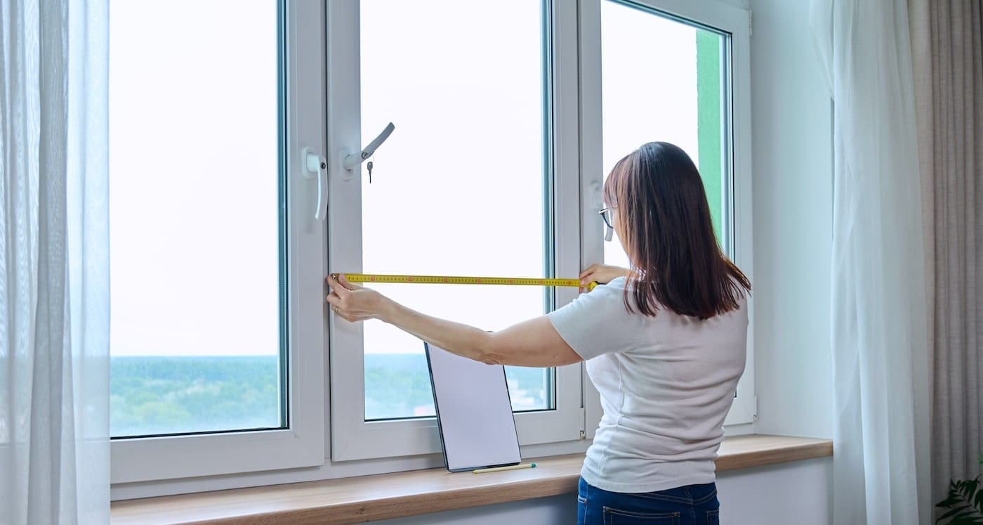 Homeowner measuring for casement windows
