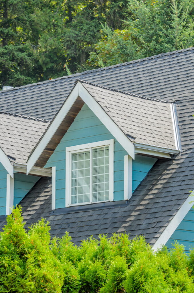 Blue House Dormer Windows with Gray Shingled Roof