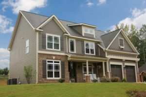 Two-story home featuring taupe horizontal siding, brown brick accents, white trim, and dark shutters.